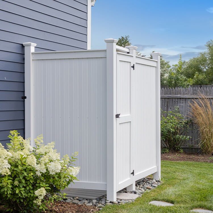 outdoor shower set against house next to plant