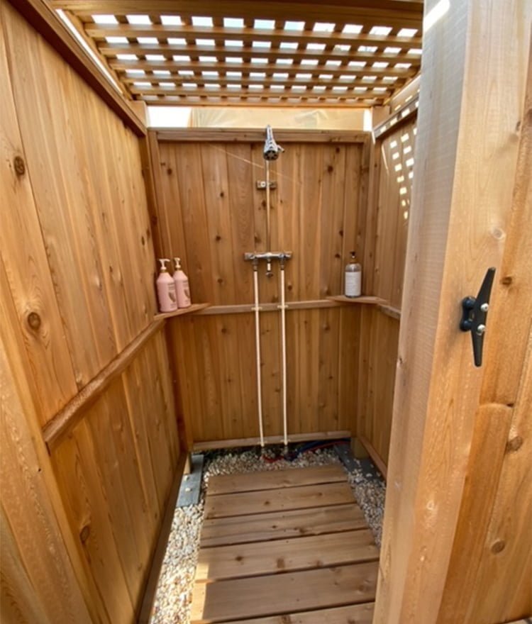 freestanding outside shower with wood lattice roof