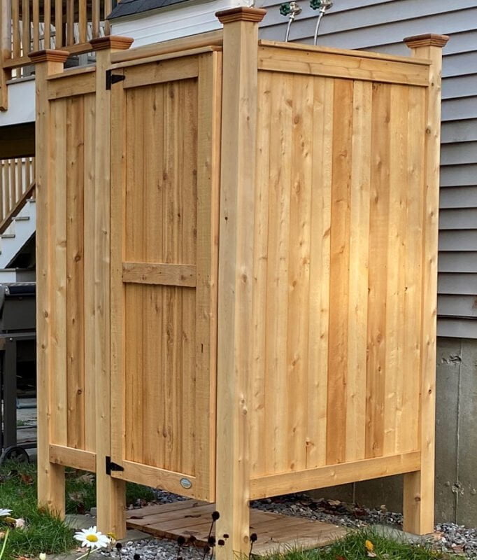 wood outdoor shower enclosure in backyard