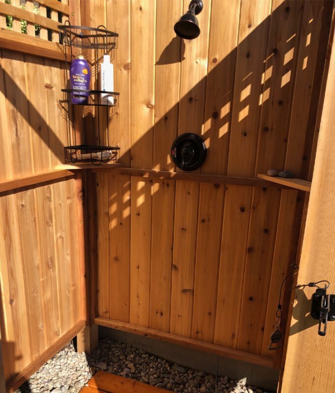 freestanding outdoor shower stall with wood lattice panels