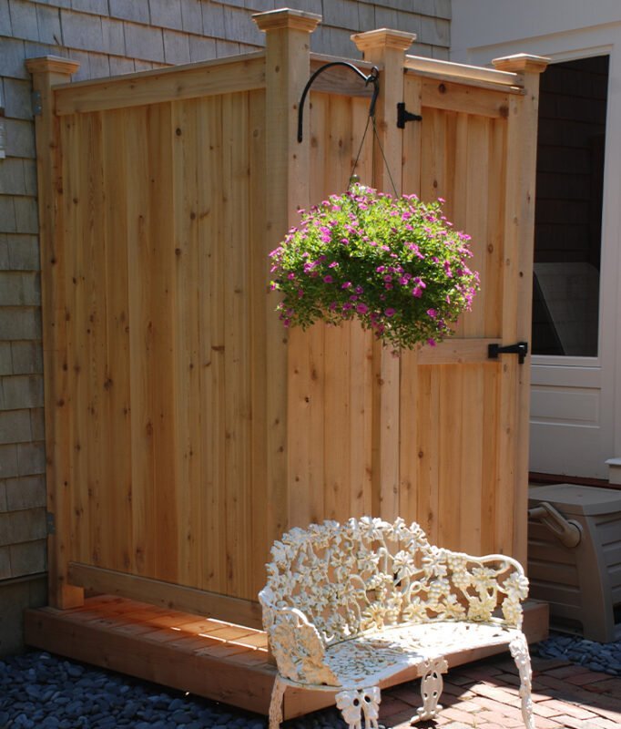 wood outdoor shower in backyard against the house