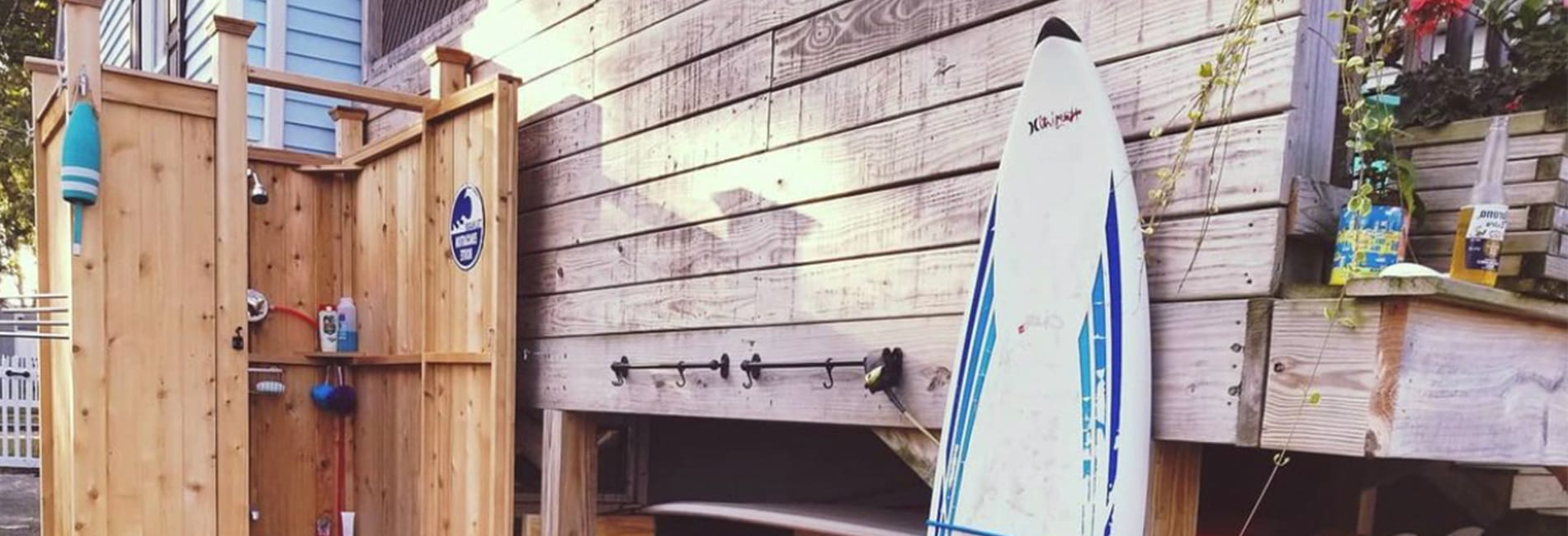 cedar grade outdoor shower with surfboard and corona