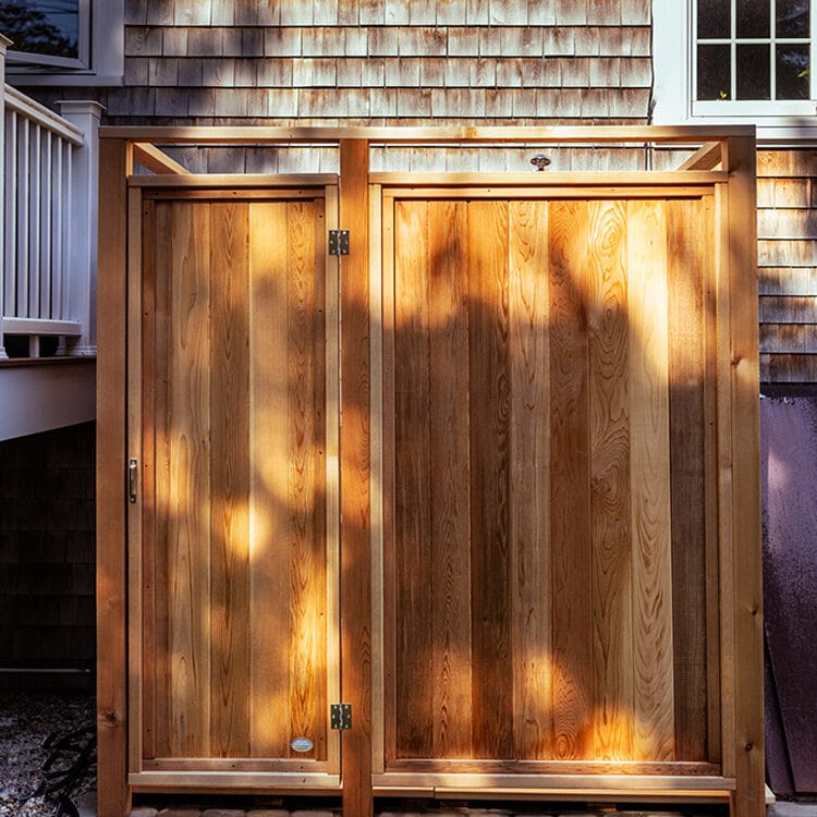 clear cedar outside shower shown against a house